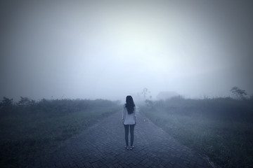 Sad woman standing alone in a misty morning - Powered by Adobe
