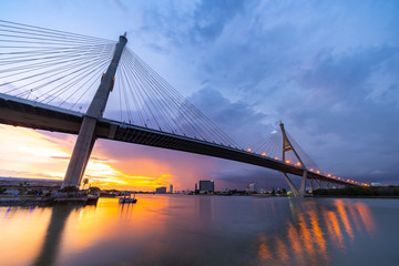 Bhumibol Bridge, the Industrial Ring Road Bridge with skyscraper in the night scene after sunset. Twilight sky and light reflection on smooth water, Thailand