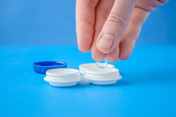 female hands taking lens out of container