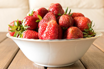 Fresh strawberries in a white plate on the table. Fresh natural berries. Close up