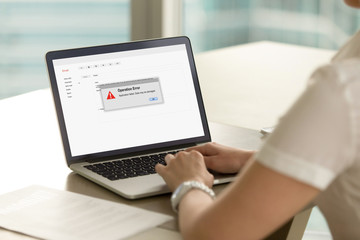 Businesswoman looks at laptop screen with Operation Error message. Entrepreneur experienced system...