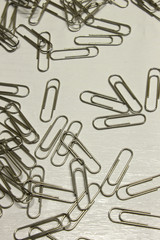 Silver Paper Clips isolated on a textured White background
