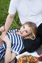 Beautiful girl rests on a picnic with a guy