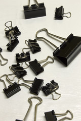 Black Binder clips isolated on a textured White background
