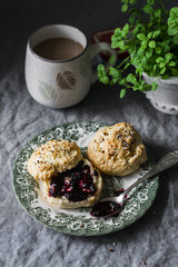 Delicious breakfast or brunch - scones with butter and jam and coffee on a cozy home table