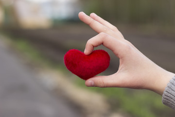 Fototapeta na wymiar Children's hands giving red heart