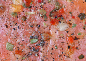 A fresh piece of salmon is marinated with lemon juice and spices.