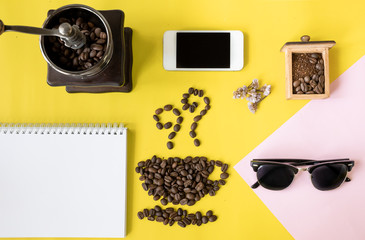 top view flat layer coffee beans in cup and smell icon shape, with vintage wooden coffee grinder, phone,  sun glasses and blank book on two tone multicoloured background