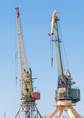 Port cargo cranes over blue sky