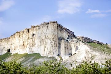 mountain  white frome  limestone in Crimea with caves  blue sky and green near  mountains 