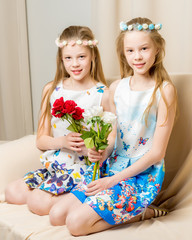 Two little girls with flowers.