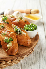 Plate with delicious homemade garlic bread on table