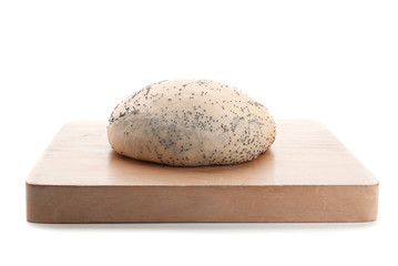 Wooden board and raw dough with poppy seeds on white background