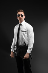 Fototapeta na wymiar Male security guard in uniform on dark background