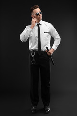Male security guard in uniform on dark background