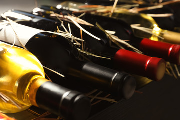 Bottles with delicious wine on shelf, closeup. Professional sommelier
