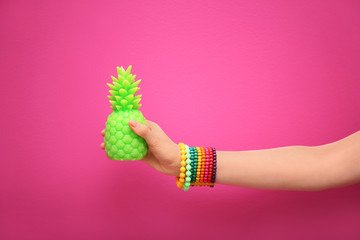 Woman holding stylish pineapple candle on color background