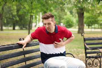 Obraz premium Young man having chest pain in park. Heart attack