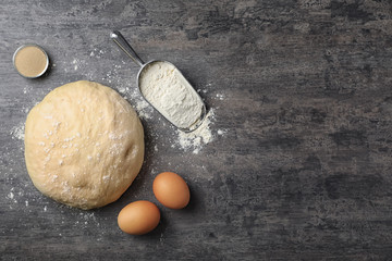 Flat lay composition with raw dough and products on grey background