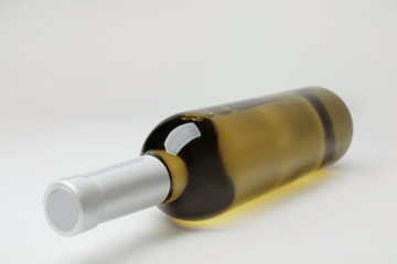 Bottle of expensive white wine on light background