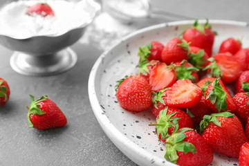 Plate with ripe red strawberries on table, closeup