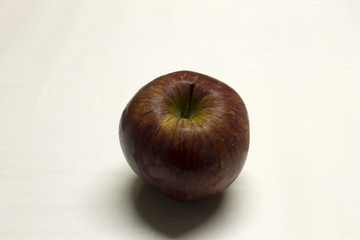 Red Apple isolated on a White textured background with a dark shadow