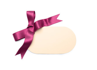 Blank gift tag with satin ribbon on white background, top view