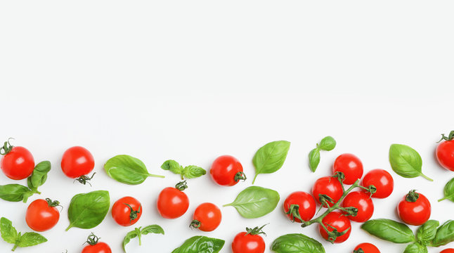Flat lay composition with tomatoes and basil on light background