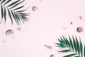 Fototapeta na wymiar Tropical palm leaves, seashells on pastel pink background. Summer concept. Flat lay, top view, copy space