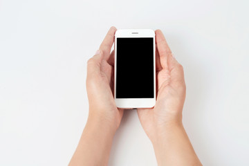 Young woman holding mobile phone with blank screen in hands on white background