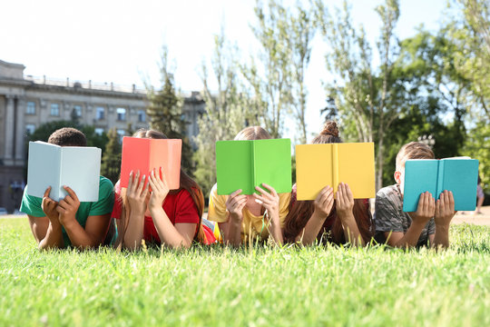 Group of children with books outdoors. Summer camp