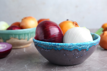 Bowl with fresh ripe onions on table