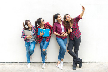 Asian group woman standing and holding a book, take a photo on wall white background. Education Concept