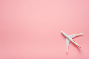 Top view of an airplane on trendy pink background.  Bright summer color. Travel concept.