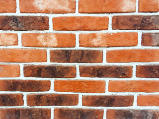 An ancient brick wall consisting of stones of red, orange, brown and dark brown bricks. Great option for background