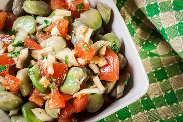 Broad bean salad with tomatoes, onion and olive