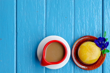 Good morning world. cup of coffee and yellow pie on blue background,top view ,empty space.