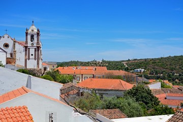 View over the town rooftops towards the countryside with the Gothic cathedral (Igreja da Misericordia) to the left hand side, Silves, Portugal. © arenaphotouk