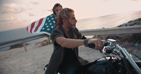 Biker couple with American flag setting off for road trip