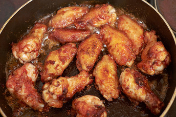 Chicken wings fried in pan with hot oil, homemade food