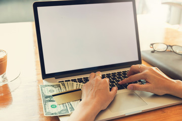 Woman using laptop to search web site for online shopping.