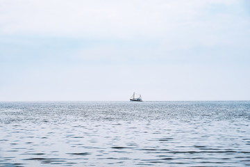 Fototapeta premium distant shrimp boat at the horizon, north sea in Germany