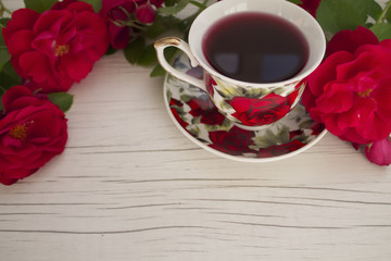 Fototapeta na wymiar cup of red tea with roses on a light background