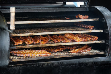 bbq spareribs in barbecue smoker, grilled pork meat ribs