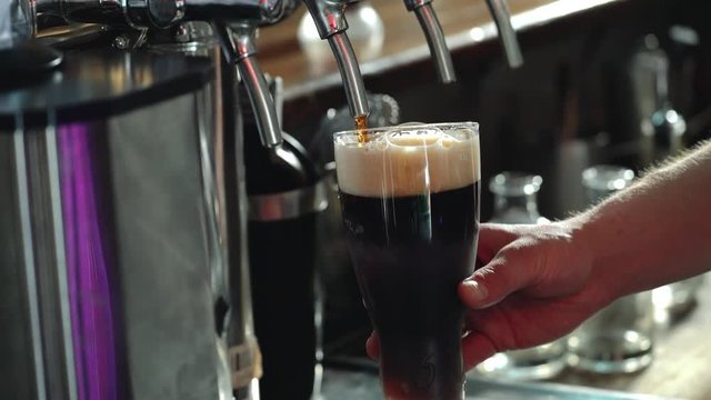 Bartender Pouring Glass of Stout Beer.