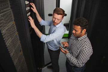 IT issue. Top view of skillful IT technicians having discussion and fixing connection