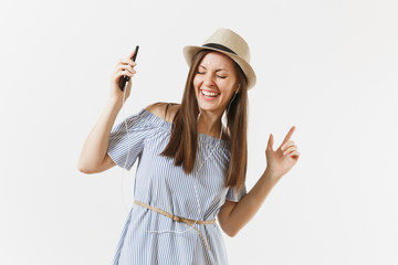 Obraz na płótnie Canvas Young charming woman in dress, hat listening music in earphones on mobile phone, enjoy, relax isolated on white background. People, sincere emotions, lifestyle concept. Advertising area. Copy space.