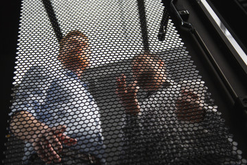 Data center. Low angle of professional IT technicians talking while having computer problem