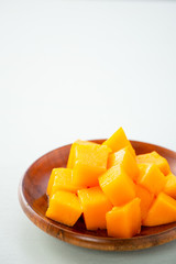 Fresh and beautiful mango fruit with sliced diced mango chunks on a light blue background, copy space(text space), blank for text.