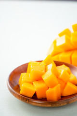 Fresh and beautiful mango fruit with sliced diced mango chunks on a light blue background, copy space(text space), blank for text.